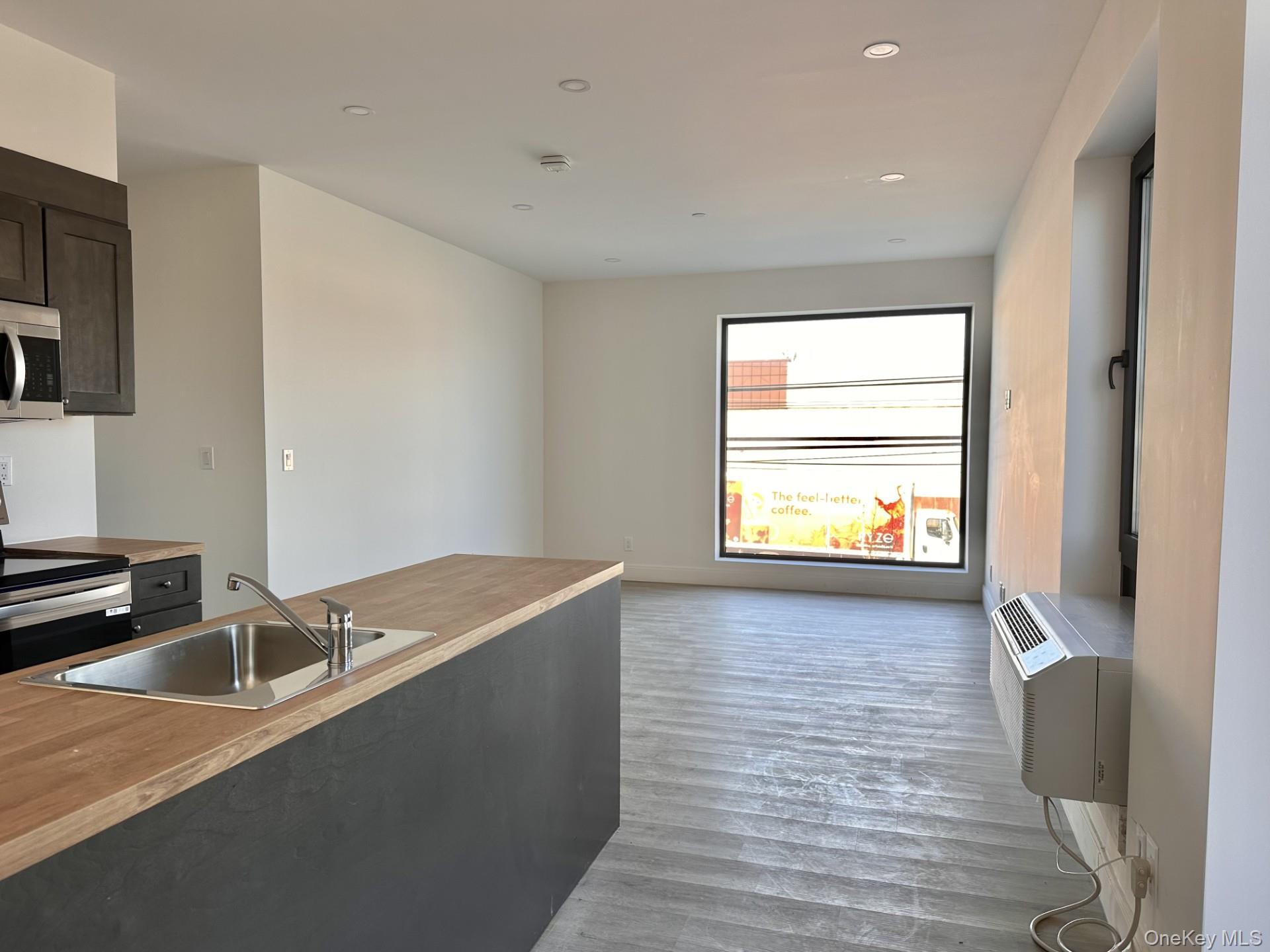 362 West Merrick Road, Unit 201 Valley Stream, NY 11580 - Photo 6 of 6 Kitchen with stainless steel appliances, dark wood-type flooring, light countertops, recessed lighting, and a wall mounted air conditioner