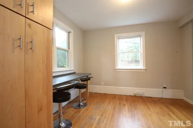 a view of a workspace with wooden floor and a window