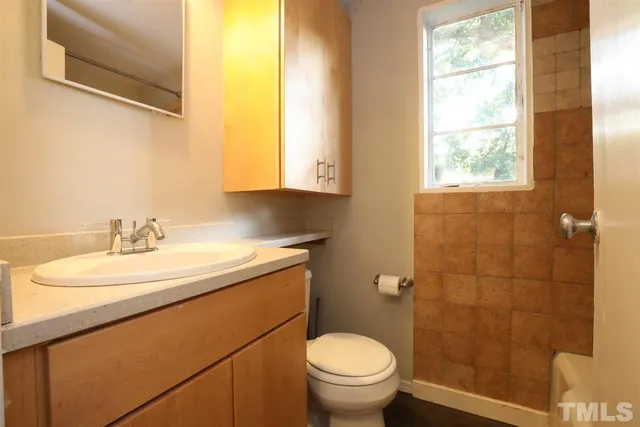 a bathroom with a granite countertop sink toilet and a mirror