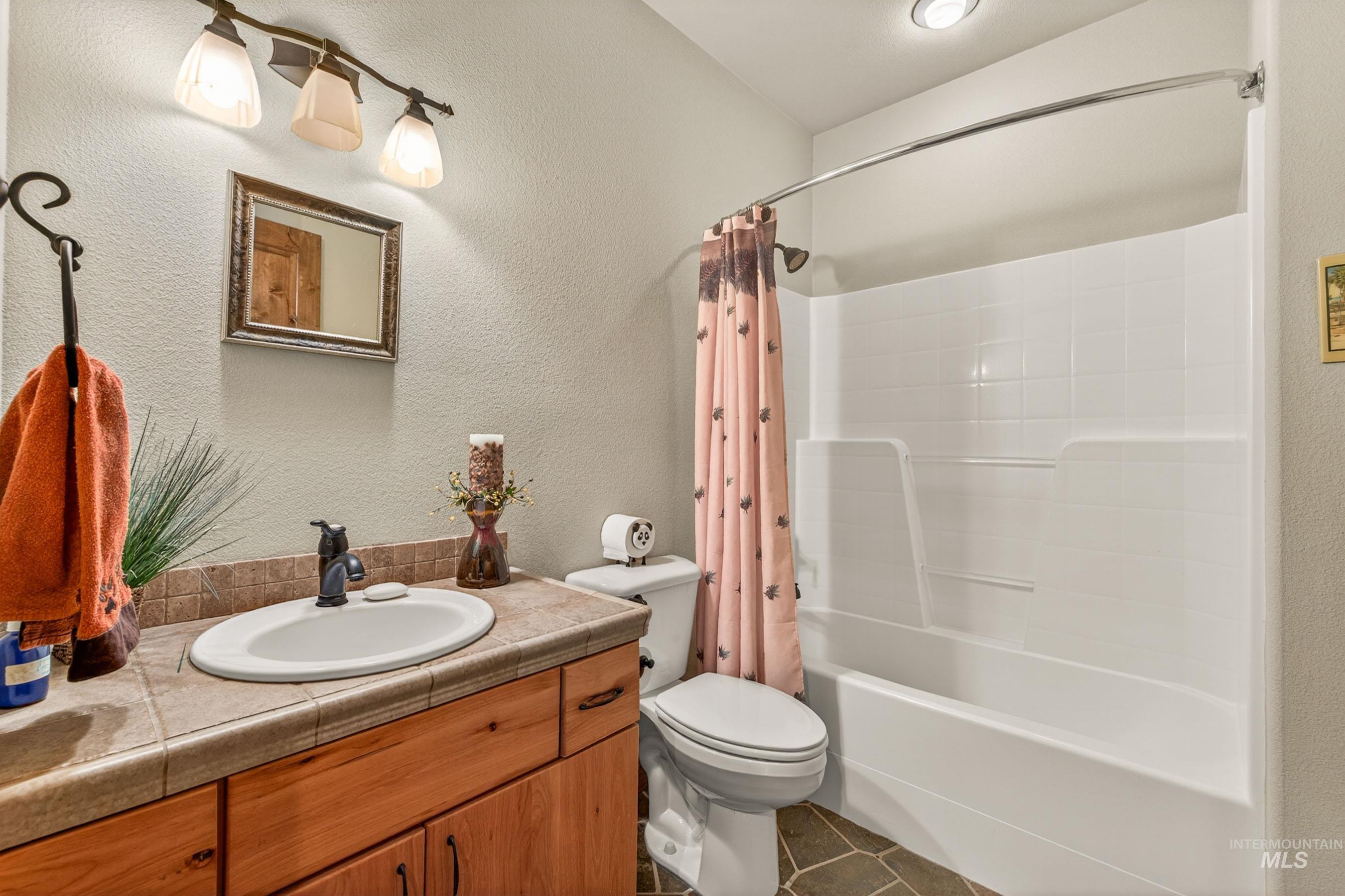 113 Deford Road White Bird, ID 83554 - Photo 24 of 49 Bathroom featuring a wood vanity with a tile countertop, an oval undermount sink, and oil-rubbed bronze fixtures