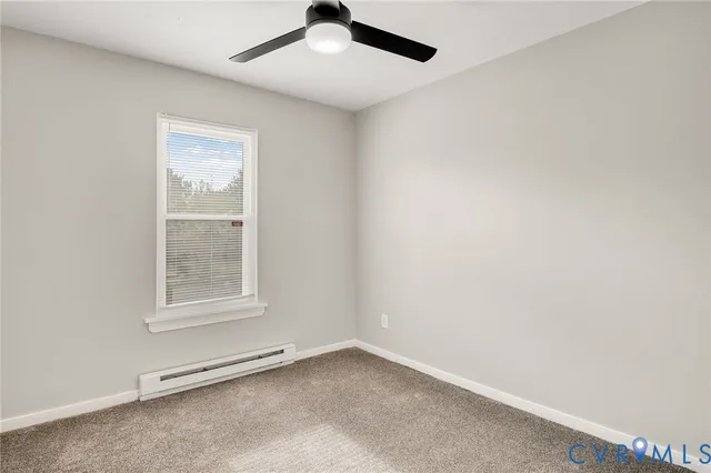 an empty room with a ceiling fan and entryway