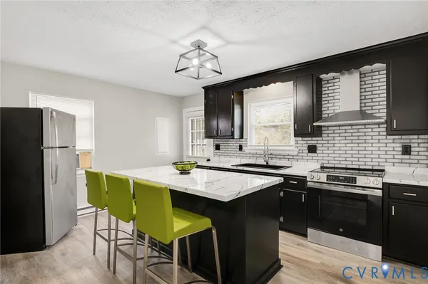 a view of a kitchen with a sink refrigerator and wooden floor
