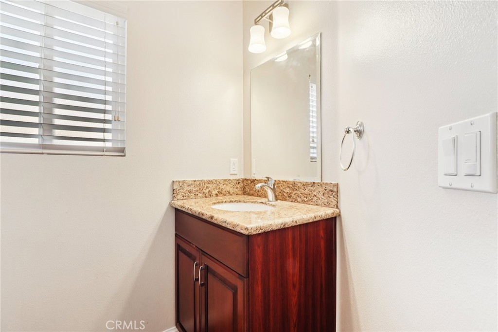 12106 Old River School Road, Unit G Downey, CA 90242 - Photo 7 of 22 a bathroom with a granite countertop sink and a mirror