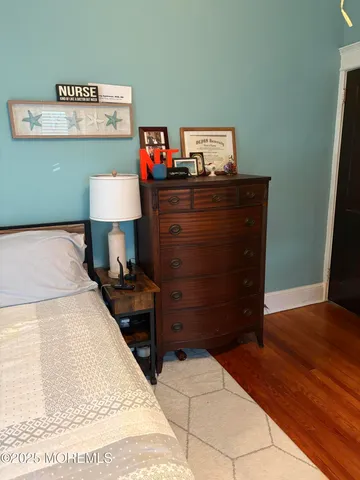 a bedroom with a bed and a lamp on dresser
