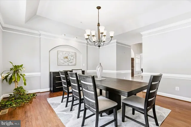 a view of a dining room with furniture a chandelier and wooden floor