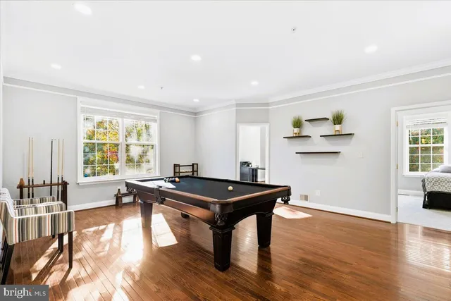 a room with wooden floor table and chairs