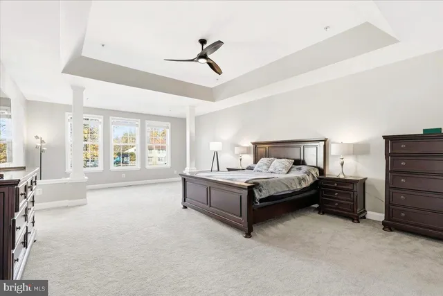 a spacious bedroom with a bed and a chandelier