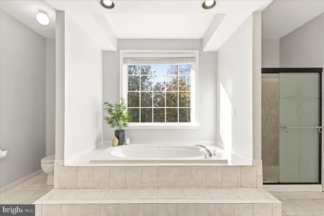 a white bath tub sitting in a bathroom next to a window