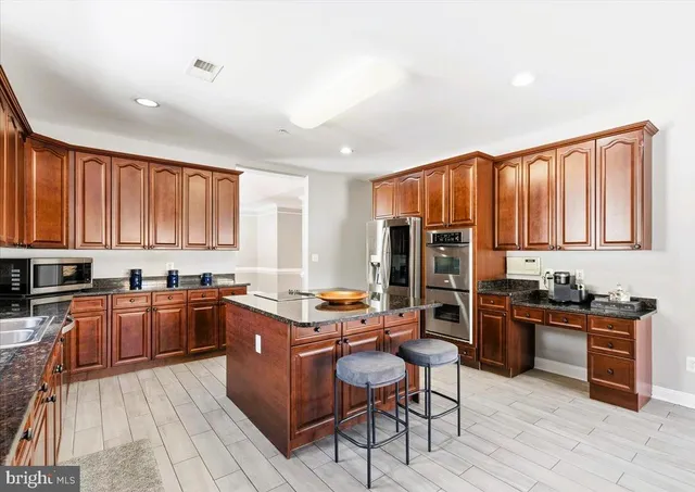 a kitchen with stainless steel appliances granite countertop a stove top oven a sink dishwasher stove and refrigerator with wooden floor