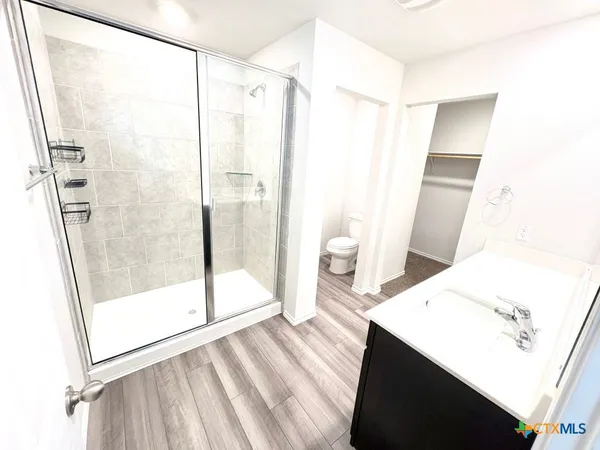 a bathroom with a sink and a glass door shower