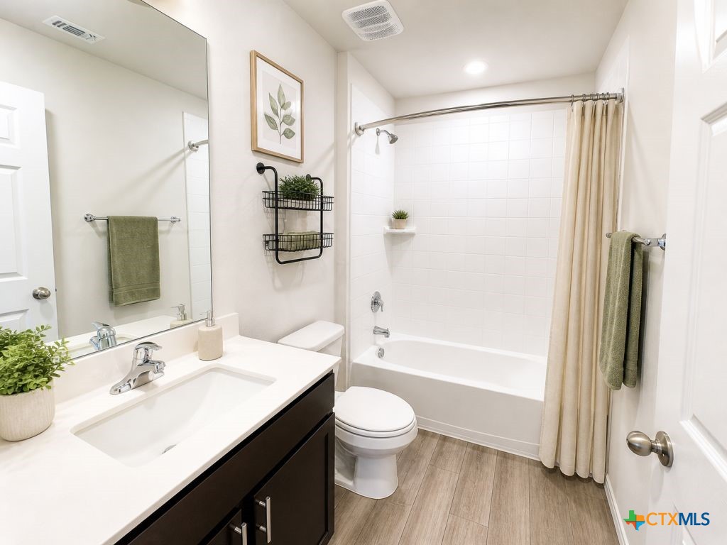 1507 Merritt Road Temple, TX 76504 - Photo 11 of 15 a bathroom with a granite countertop sink toilet a large mirror a shower and a bathtub