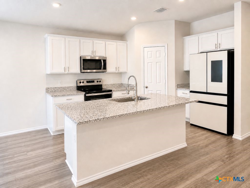 1507 Merritt Road Temple, TX 76504 - Photo 3 of 15 a kitchen with granite countertop a refrigerator stove top oven and sink