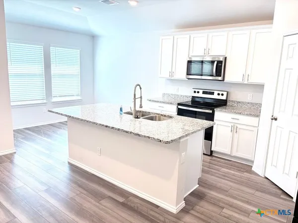 a kitchen with a sink stove top oven and microwave