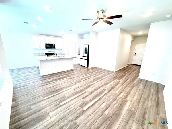 a view of kitchen with sink microwave and stove top oven