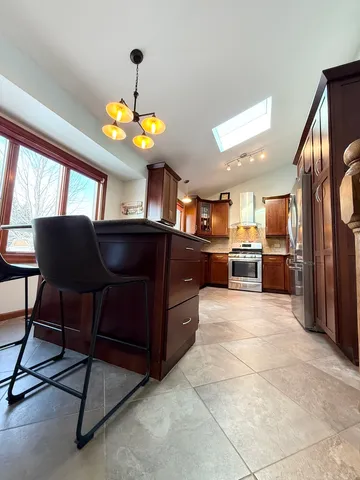 a kitchen with stainless steel appliances granite countertop a sink dishwasher and a refrigerator