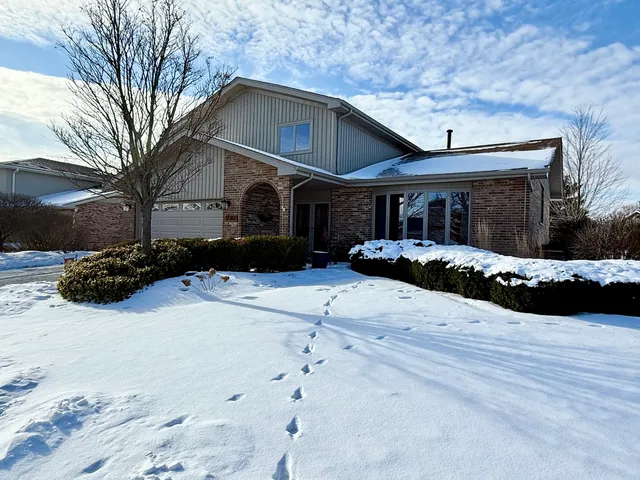 a front view of a house with a yard covered in snow