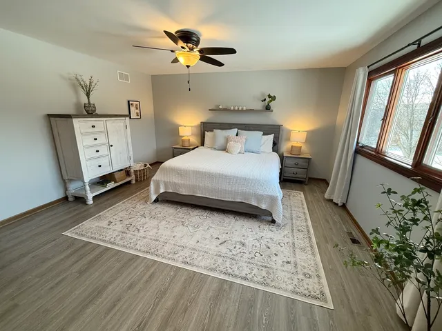 a bedroom with a bed chandelier and a window
