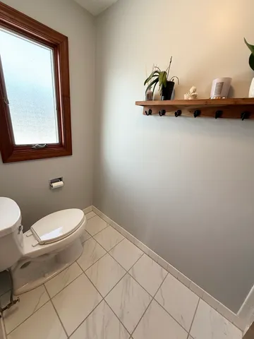 a bathroom with a toilet a sink and mirror