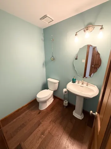 a bathroom with a toilet sink and mirror