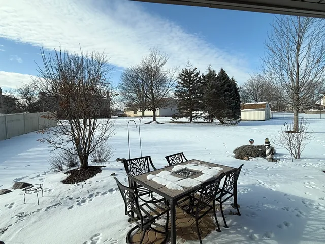 a view of a backyard dining space with a table and chairs