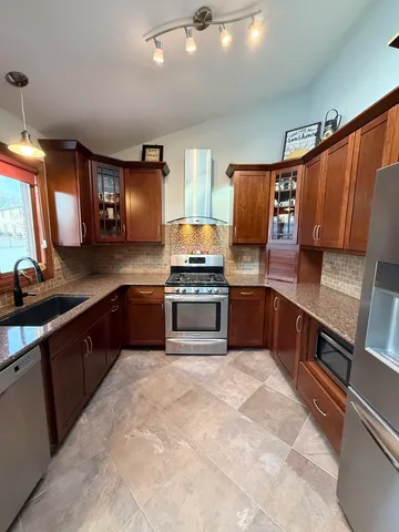 a kitchen with granite countertop stainless steel appliances and wooden cabinets