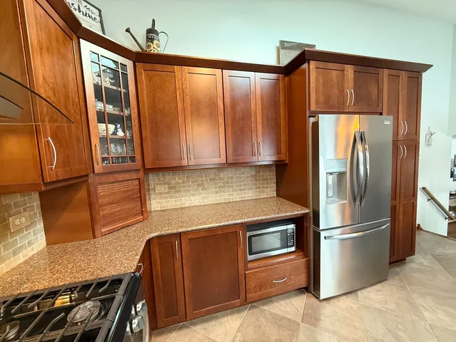 a kitchen with stainless steel appliances granite countertop a refrigerator and a sink