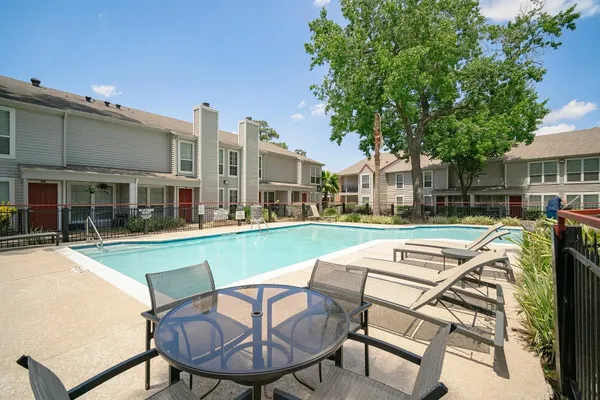 a view of house with swimming pool and outdoor seating