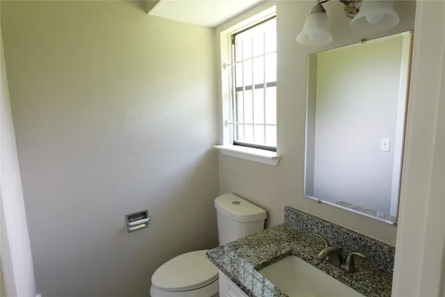 a bathroom with a sink toilet and window
