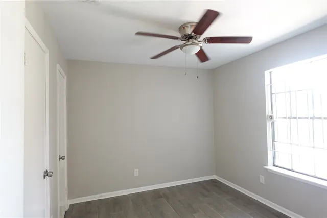 an empty room with window and wooden floor