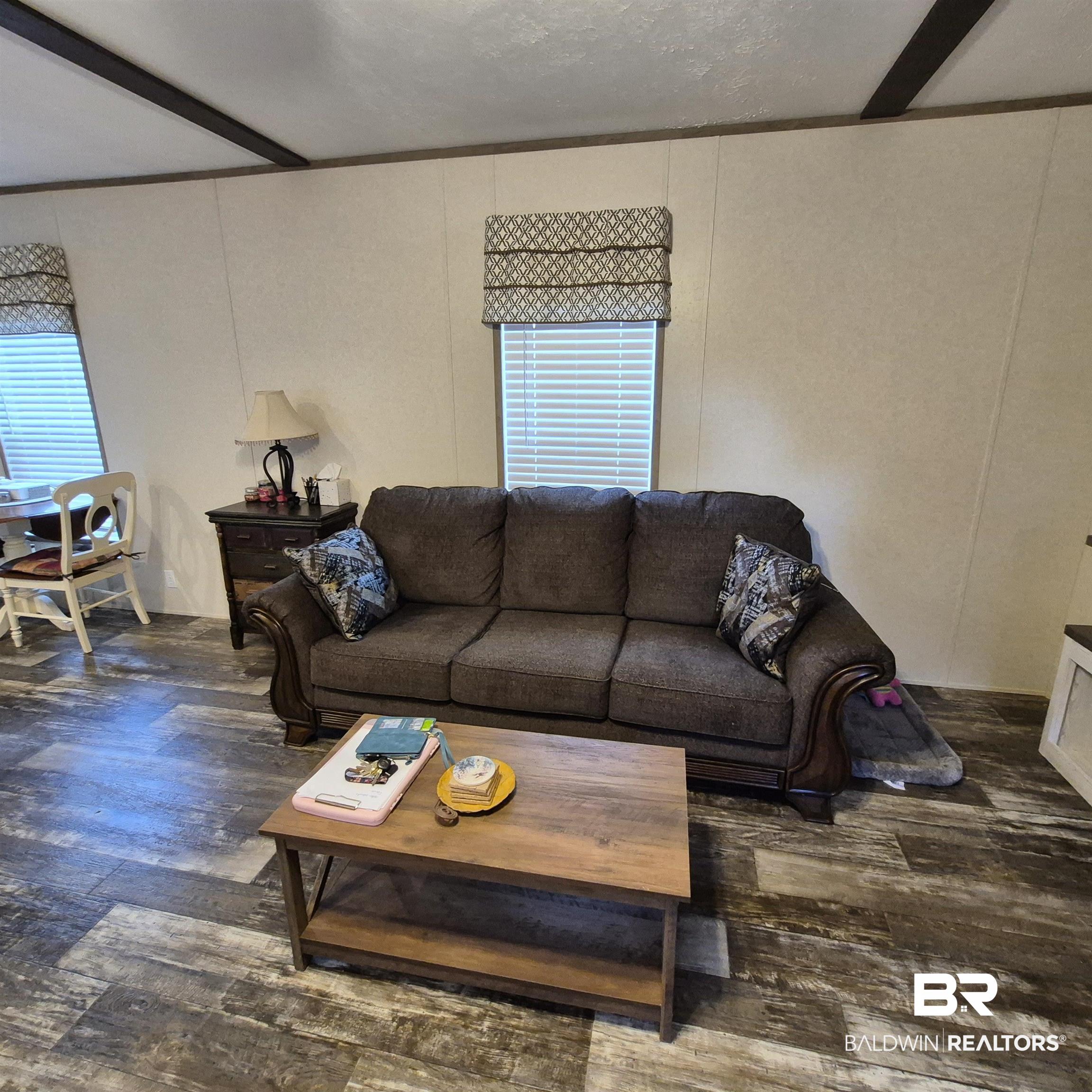 4790 Brooklyn Road Evergreen, AL 36401 - Photo 5 of 30 Living area featuring dark wood finished floors, a decorative wall, and healthy amount of natural light