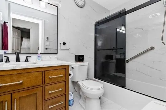 a bathroom with a granite countertop sink toilet and shower