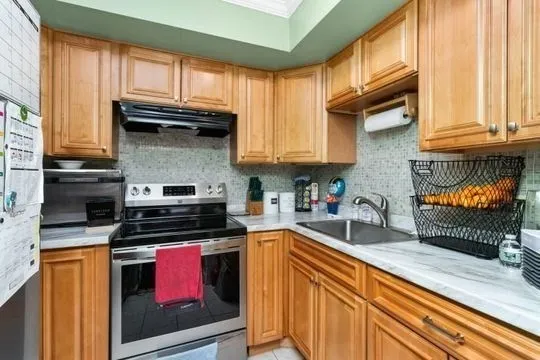 a kitchen with stainless steel appliances granite countertop a stove a sink and a microwave