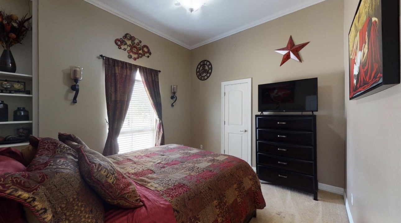 104 Mockingbird Lane Bridge City, TX 77611 - Photo 21 of 27 a bedroom with a bed and a flat tv screen