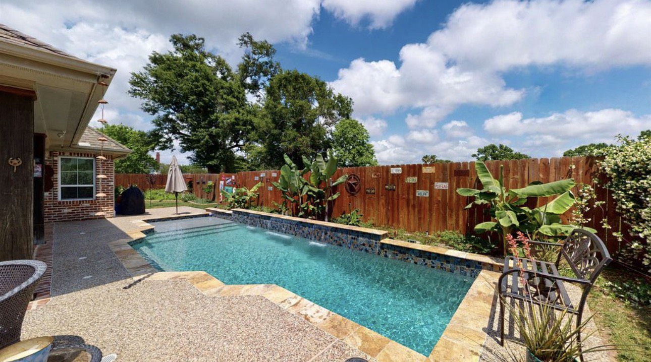 104 Mockingbird Lane Bridge City, TX 77611 - Photo 26 of 27 a backyard of a house with table and chairs plants and large trees