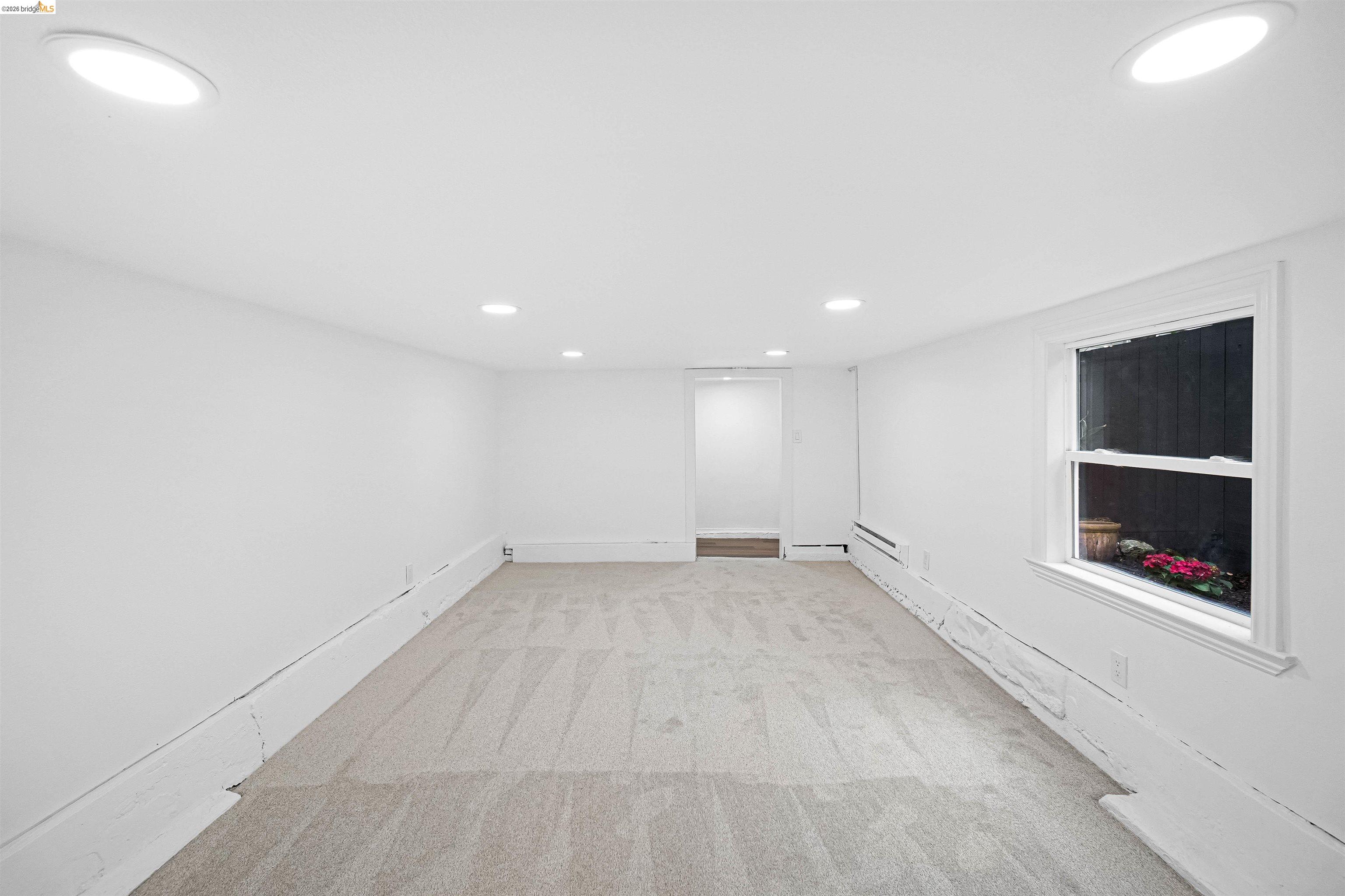 1812 Woolsey Street Berkeley, CA 94703 - Photo 44 of 48 Carpeted room featuring recessed lighting, a single window, and a baseboard heating unit