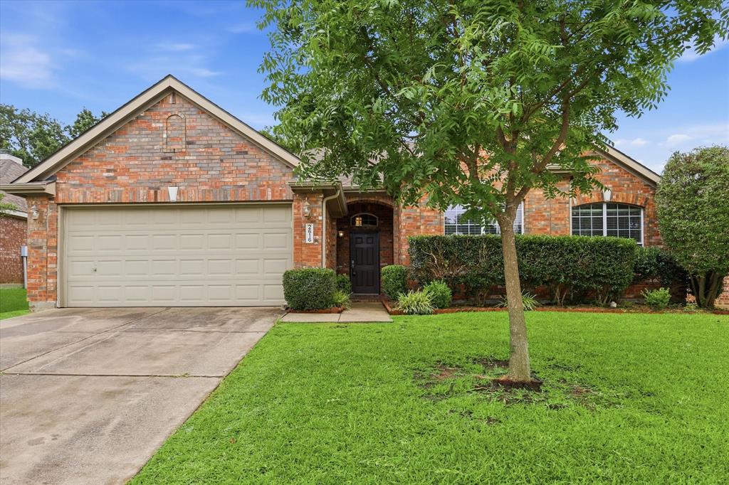 2616 Hollow Ridge Drive Denton, TX 76210 - Photo 4 of 31 Brick facade residence with an attached garage, arched entry, and established landscaping