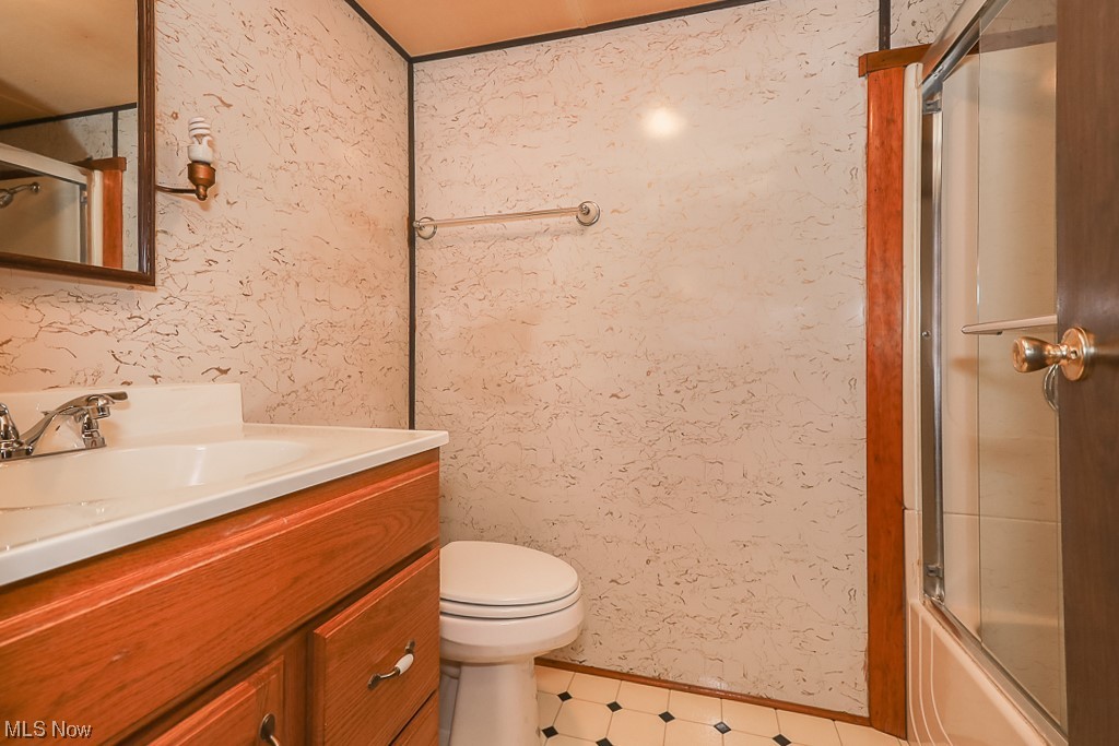9920 Reed Road Grafton, OH 44044 - Photo 16 of 28 Full bathroom featuring shower / bath combination with glass door, vanity, and tile floors