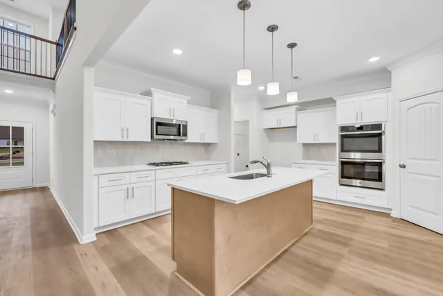 a kitchen with kitchen island a sink stainless steel appliances and cabinets