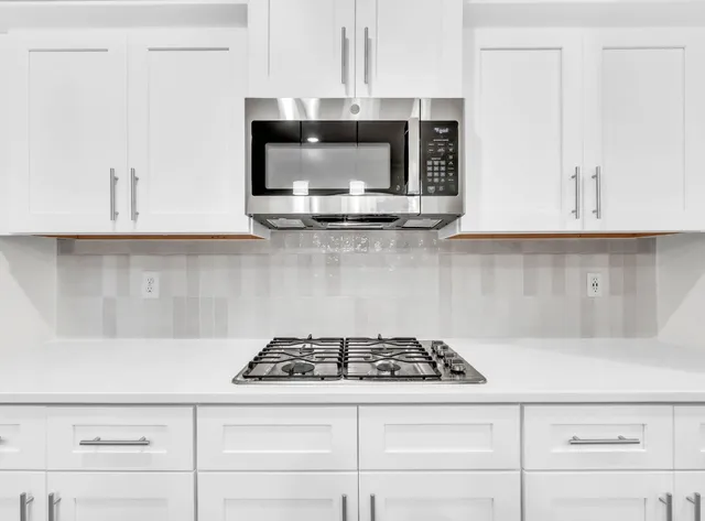 a stove top oven sitting inside of a kitchen