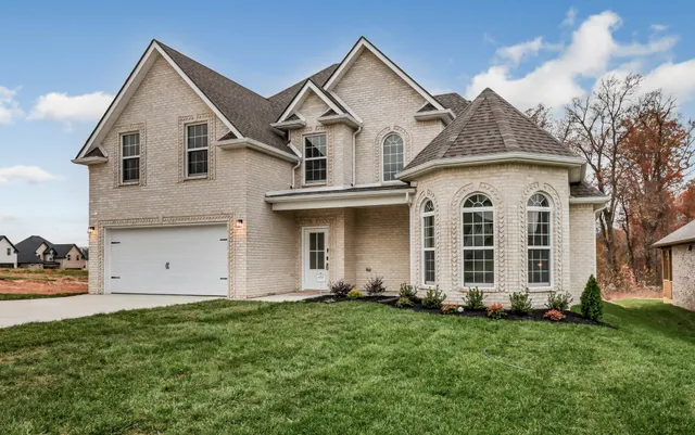 a view of a white house with yard and plants