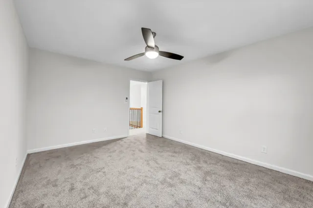 en empty room with windows and ceiling fan