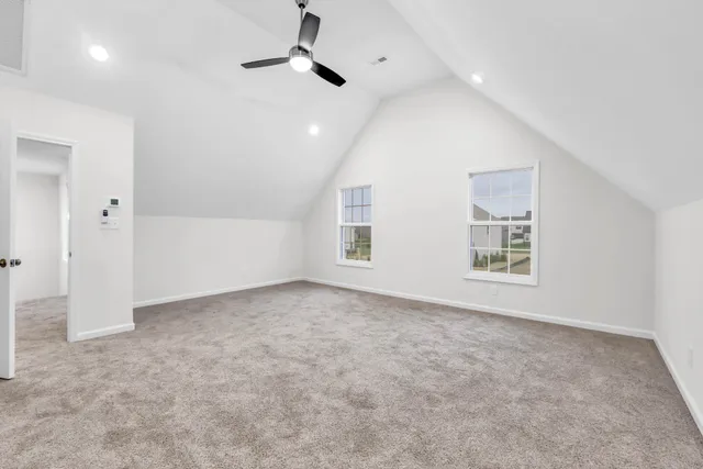 an empty room with a ceiling fan and carpet