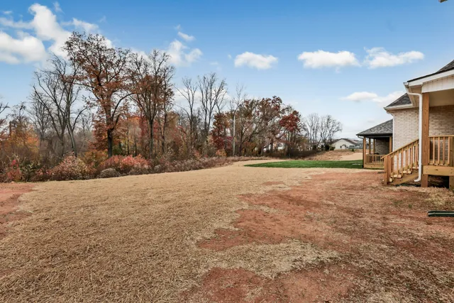 a view of a house with a yard and lake view