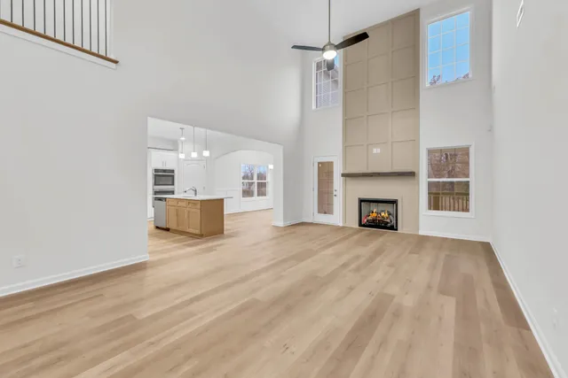 a view of empty room with wooden floor and fireplace