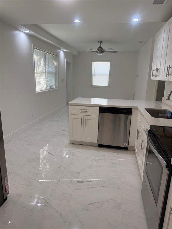 305 Ann Street Edgewater, FL 32132 - Photo 25 of 45 a kitchen with white cabinets and a fireplace