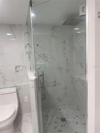a bathroom with a granite countertop shower and a sink