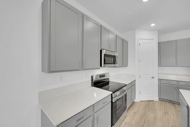 a kitchen with white cabinets and stainless steel appliances