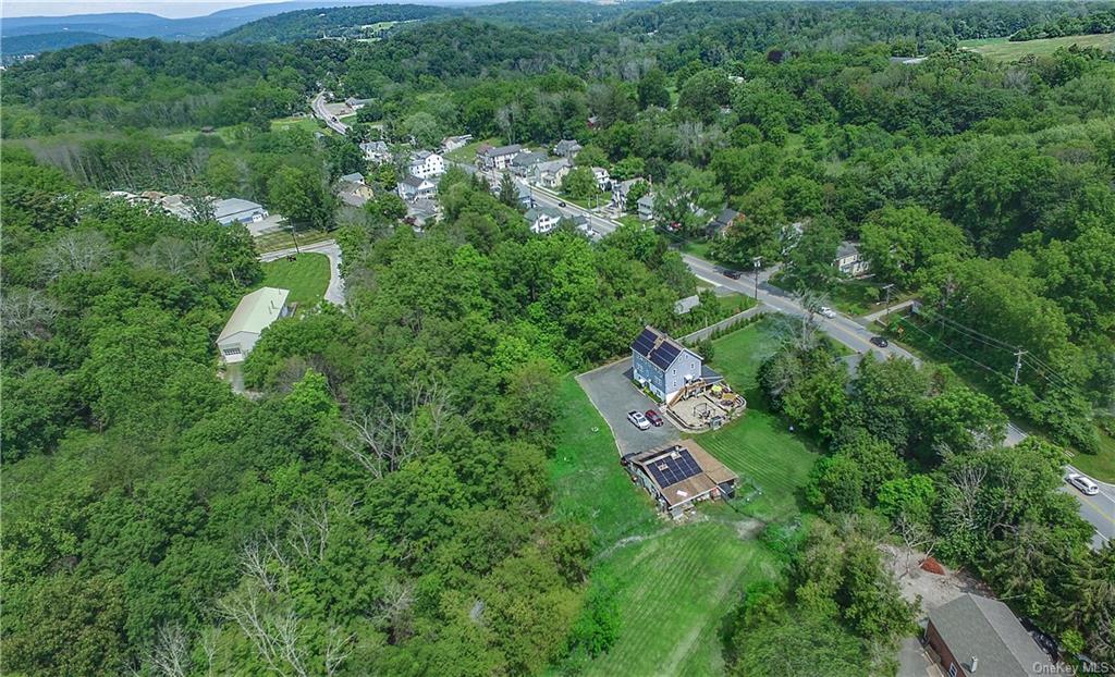 an aerial view of residential house with outdoor space and trees all around