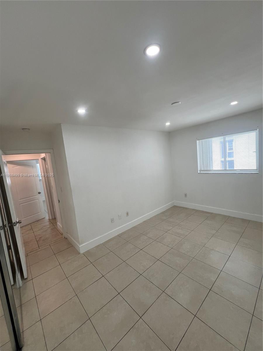 Edgewater Miami, FL 33137 - Photo 23 of 29 an empty room with white walls and sliding door