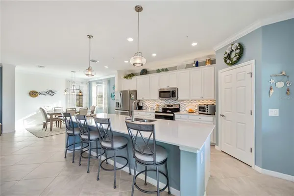 a dining room with furniture a chandelier and wooden floor